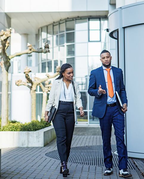 A handsome black ethnicity businessman and a beautiful young female colleague going back to the office after lockdown